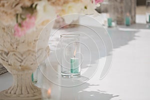 Beautiful bouquet of roses in a vase on a background of a wedding arch. Beautiful set up for the wedding ceremony.