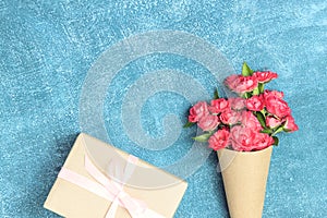 Beautiful bouquet of small red roses in vintage paper on the table.