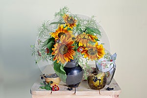 Beautiful bouquet of sunflowers in a vase and black currant berries. Still life with flowers and berries