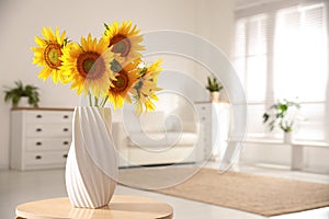 Beautiful bouquet of sunflowers in vase on table indoors. Space for text