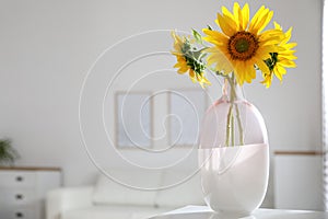 Beautiful bouquet of sunflowers in vase on table indoors. Space for text