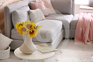 Beautiful bouquet of sunflowers in vase on white table indoors. Space for text