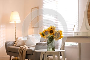 Beautiful bouquet of sunflowers in vase on white table indoors. Space for text