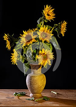 Beautiful bouquet of sunflowers in vase on a wooden table