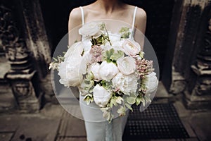 Beautiful bouquet of white peonies in the hands of the bride. Wedding accessories