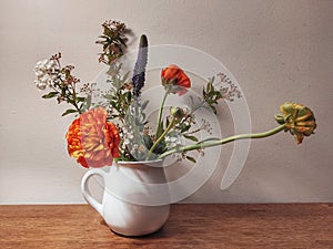 Beautiful bouquet of wild flowers in a white vase