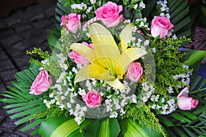 Beautiful bouquet of yellow lilly and pink rose flowers in a gift basket nature background