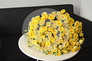 Beautiful bouquet of yellow rose bushes on a white table