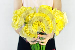 Beautiful bouquet of yellow terry tulips flowers in woman hands. Women`s day, mother`s day