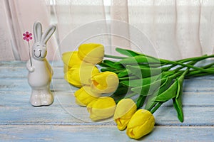 Beautiful bouquet of yellow tulips on a blue wooden background.