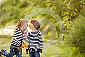 Beautiful boy and girl in a park, boy giving flowers to the girl