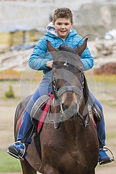 Beautiful boy and girl riding horses on the green meado photo