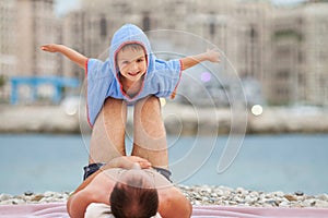 Beautiful boy, making airplane with hands, dad holding him on hi