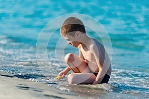 Beautiful boy playing with toys at the seaside