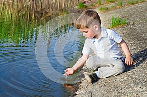 Beautiful boy pours water from the palm