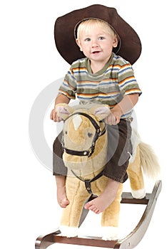 Beautiful boy rides rocking horse