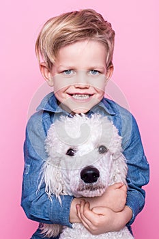 Beautiful boy with Royal Standard Poodle. Studio portrait over pink background. Concept: friendship between boy and his dog