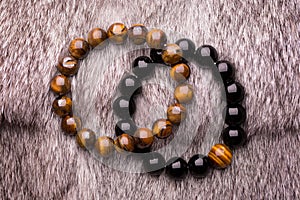 A beautiful bracelet of black stones lying on gray fur