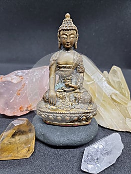 Beautiful brass Buddha statue sitting on a stone