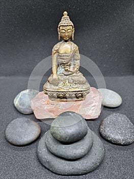 Beautiful brass Buddha statue sitting on a stone