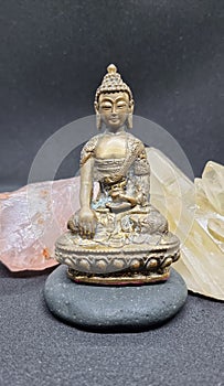 Beautiful brass Buddha statue sitting on a stone