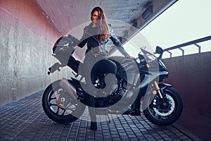 Beautiful brave woman is leaning on her motobike in tunnel