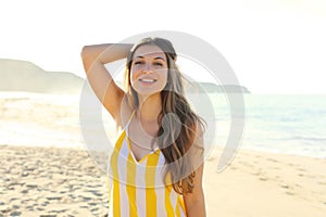 Beautiful brazilian woman in summer dress on tropical beach. Portrait of happy young woman smiling at sea. Happy cheerful girl