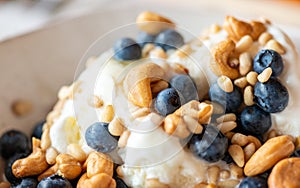 Beautiful breakfast - ice cream, berries cashew, cedar, blueberry and honey in the plate. Good morning. Macro