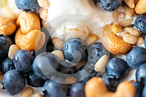 Beautiful breakfast - ice cream, berries cashew, cedar, blueberry and honey in the plate. Good morning. Macro