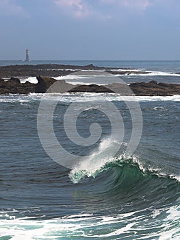 Beautiful Breton wave and lighthouse in background