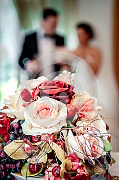 Beautiful bridal bouquet and bride and groom on background, selective focus