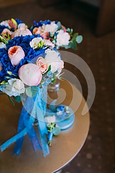 Beautiful bridal bouquet with creamy roses and peonies and blue hydrangeas. Wedding morning. Close-up