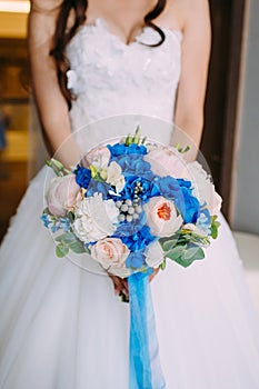 Beautiful bridal bouquet with creamy roses and peonies and blue hydrangeas. Wedding morning. Close-up