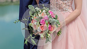 Beautiful bridal bouquet in hands of the bride. Wedding bouquet of peach roses by David Austin, single-head pink rose aqua,