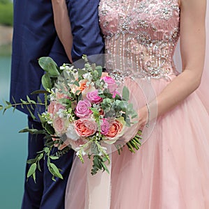 Beautiful bridal bouquet in hands of the bride. Wedding bouquet of peach roses by David Austin, single-head pink rose aqua,