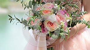 Beautiful bridal bouquet in hands of the bride. Wedding bouquet of peach roses by David Austin, single-head pink rose aqua,