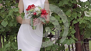 Beautiful bridal bouquet in hands of young bride dressed in white wedding dress