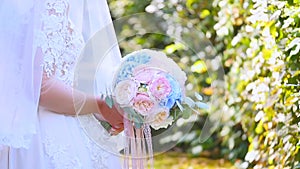 Beautiful bridal bouquet in hands of young bride dressed in white wedding dress