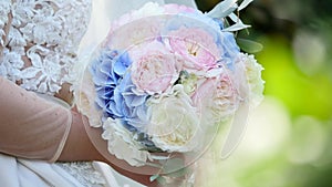 Beautiful bridal bouquet in hands of young bride dressed in white wedding dress