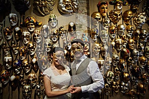 Beautiful bridal couple in carnaval masks in Venice