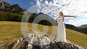 Beautiful bride with arms up in nature