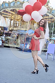 Beautiful bride with balloons in the park