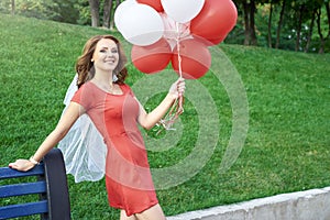 Beautiful bride with balloons in the park