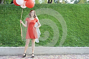 Beautiful bride with balloons in the park