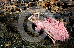 Beautiful bride blonde female model in amazing wedding dress poses on the island of Santorini