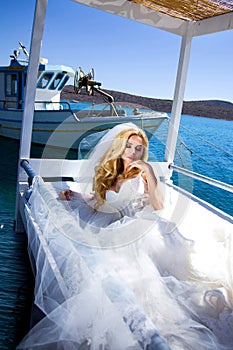 Beautiful bride blonde female model in amazing wedding dress poses on the island of Santorini