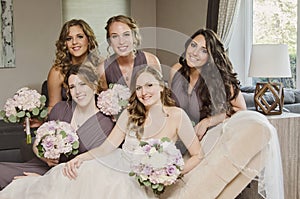 Beautiful bride and bridesmaids on couch