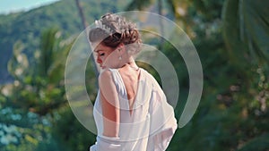 Beautiful bride dances against the sea on her wedding day