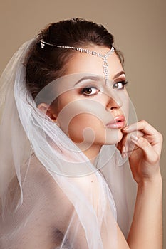 Beautiful bride with fashion wedding hairstyle with a tiara in her hair - on white background.Closeup portrait of gorgeous bride