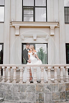 Beautiful bride and groom blonde on the balcony of a classic building.